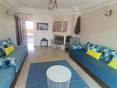 a living room with two blue couches and a table at Passadena Village, Sidi Rahal in Sidi Rahal