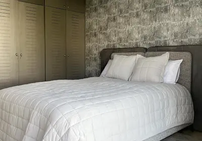 a white bed with white pillows in a bedroom at Villa de luxe avec piscine privée au cœur de Casablanca, Maroc in Casablanca