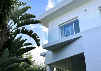 a white house with a window and a palm tree at Villa de luxe avec piscine privée au cœur de Casablanca, Maroc in Casablanca