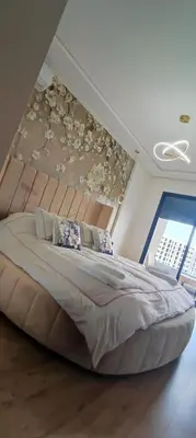 a large bed in a bedroom with a wall at Le Cocon d'Oasis - Location journalière Casablanca in Casablanca