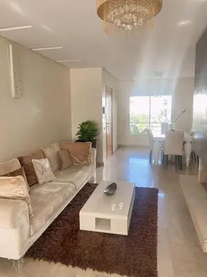 a living room with a couch and a table at Luxueux appartement Bay view dans une résidence avec magnifique jardin in Casablanca