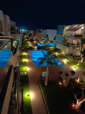 a view of a swimming pool at night at Bleu Beach uniquement pour famille in Sidi Rahal