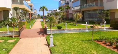 a walkway in a park next to a building at Bleu Beach uniquement pour famille in Sidi Rahal
