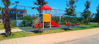 a playground with a slide in a park at Bleu Beach uniquement pour famille in Sidi Rahal