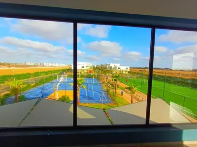 a view of a tennis court from a window at Bleu Beach uniquement pour famille in Sidi Rahal