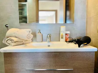 a bathroom sink with towels and a mirror at DreamParc - Vue sur Mer et Parc Securite 24H in Mohammedia