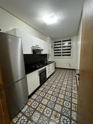 a kitchen with a refrigerator and a tile floor at Maison Bleu in Mansouria