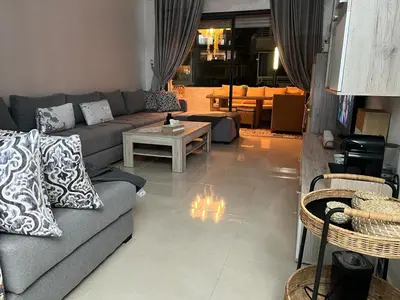 a living room with a couch and a table at Maison Bleu in Mansouria
