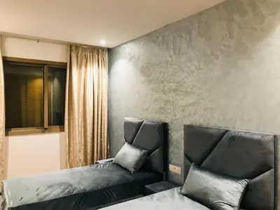 a bedroom with two beds and a window at THE luxurious and romantic pearl apartment in Mohammedia