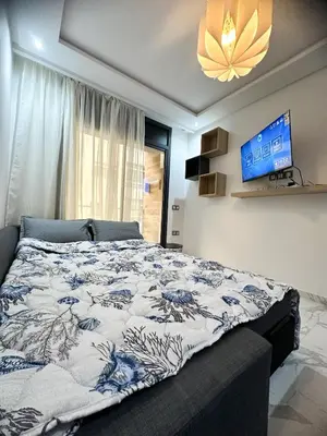 a bedroom with a bed and a flat screen tv at Appartement BMK N-1 in Rabat