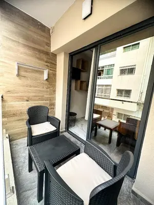 a balcony with chairs and tables on a building at Appartement BMK N-1 in Rabat