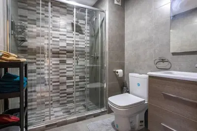 a bathroom with a shower and a toilet and a sink at Modern Charm at Le Joyau du Parc in Mohammedia