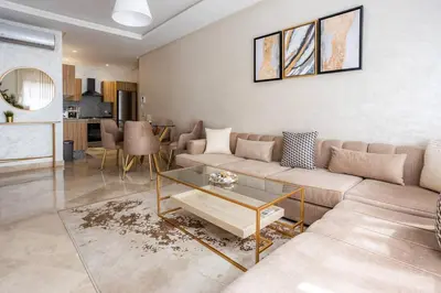 a living room with a couch and a table at Modern Charm at Le Joyau du Parc in Mohammedia