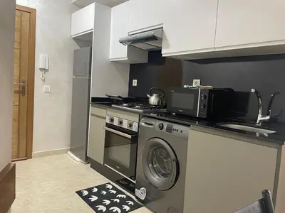 a kitchen with a stove and a washing machine at Studio meublé neuf à louer in Casablanca