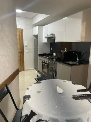 a kitchen with a table and a kitchen with a stove at Studio meublé neuf à louer in Casablanca
