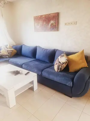 a blue couch in a living room with a table at Residence Puerto Banus in Mohammedia
