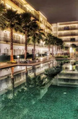 a large building with palm trees and a swimming pool at superbe appartement en résidence balnéaire in Bouznika