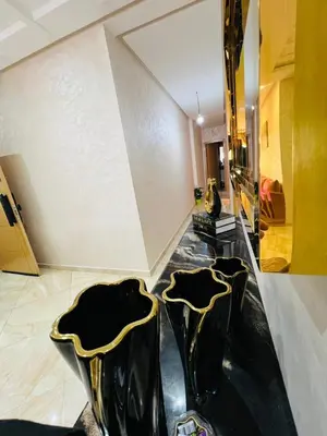 two black and gold chairs in a room at superbe appartement en résidence balnéaire in Bouznika
