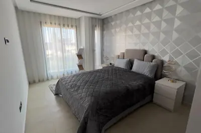 a bedroom with a large bed with a gray blanket at Villa Jack Beach in Tamaris