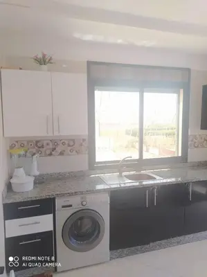 a kitchen with a washing machine and a window at Appartement vue sur mer sidi Rahal in Sidi Rahal