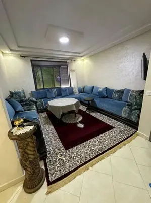 a living room with a blue couch and a table at Appartement vue sur mer sidi Rahal in Sidi Rahal