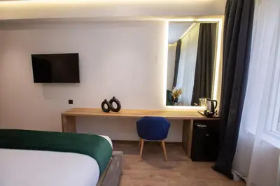 a bedroom with a bed and a desk with a mirror at Le M Hôtel in Rabat