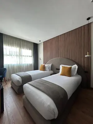 a hotel room with two beds and a window at Le M Hôtel in Rabat