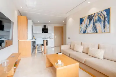 a living room with a couch and a table at StayInn - Studio luxueux & cosy avec terrasse aménagée in Casablanca