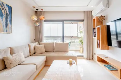 a living room with a couch and a table at StayInn - Studio luxueux & cosy avec terrasse aménagée in Casablanca