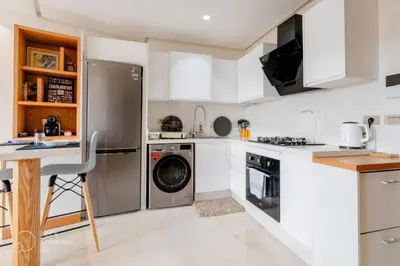 a kitchen with white cabinets and a dishwasher at StayInn - Studio luxueux & cosy avec terrasse aménagée in Casablanca
