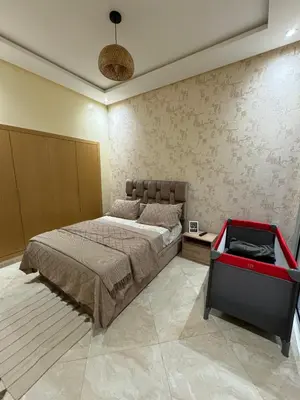 a bedroom with a large bed and a red table at CASA BAY BEACH OMK 2 in Sidi Rahal