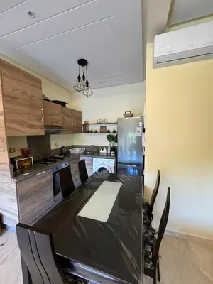 a kitchen with a black table and a refrigerator at CASA BAY BEACH OMK 2 in Sidi Rahal