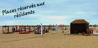 a beach with a building and people on the beach at CASA BAY BEACH OMK 2 in Sidi Rahal