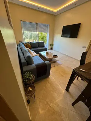 a living room with a couch and a table at CASA BAY BEACH OMK 2 in Sidi Rahal