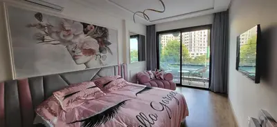 a bedroom with a pink bed and a large window at Chez Joe - Location journalière Casablanca in Casablanca