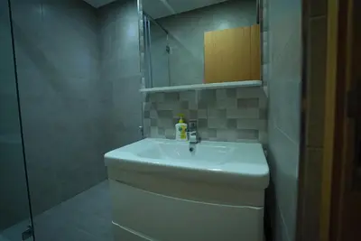 a bathroom with a white sink and a shower at New Appartment in Rabat