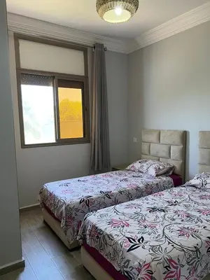 a bedroom with two beds and a window at Maison de Campagne in Dar SaÃ¯d Ben Hajj