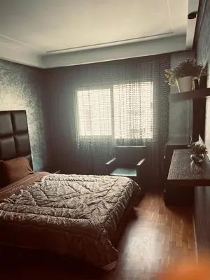 a bedroom with a bed and a table and a window at Luxury apartments 3 in Casablanca