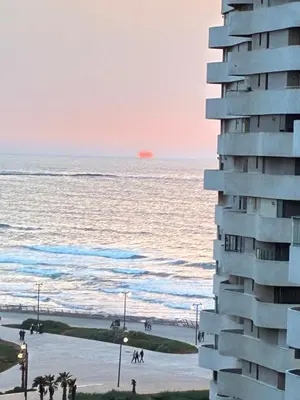 a building on the beach with the ocean in the background at Casablanca Marina by Saloua in Casablanca