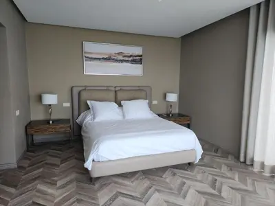 a bedroom with a white bed and two night tables at Casablanca Marina by Saloua in Casablanca