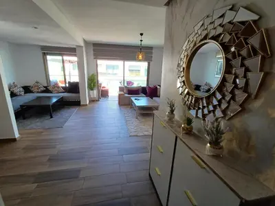 a living room with a mirror on the wall at Sidi Rahal Bleu Beach family in Sidi Rahal