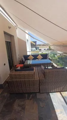 a living room with two couches and a balcony at Sidi Rahal Bleu Beach family in Sidi Rahal
