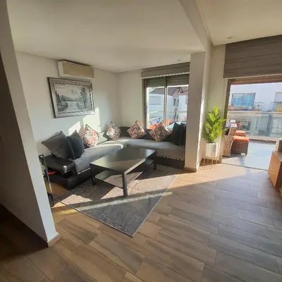 a living room with a couch and a table at Sidi Rahal Bleu Beach family in Sidi Rahal