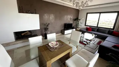 a living room with a table and a couch at Nouaceur Garden in Casablanca