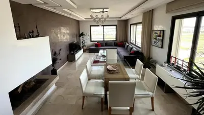a living room with a table and a couch at Nouaceur Garden in Casablanca