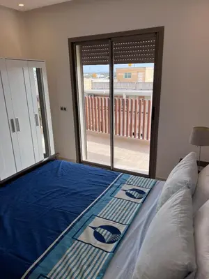 a bedroom with a bed and a large window at North Beach Plage & Confort in Mansouria