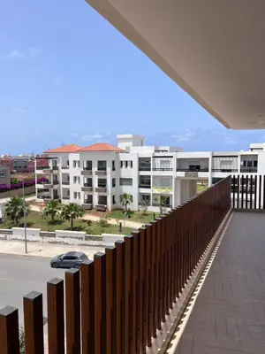 a balcony with a wooden fence and a parking lot at North Beach Plage & Confort in Mansouria