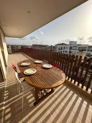 a wooden table and chairs on a balcony at North Beach Plage & Confort in Mansouria