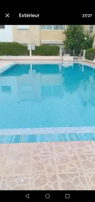 a large swimming pool with blue water at Maison du bonheur in El Harhoura