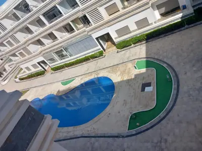 a building with a swimming pool in front of it at Bel Appartement à Mansbay in Mansouria